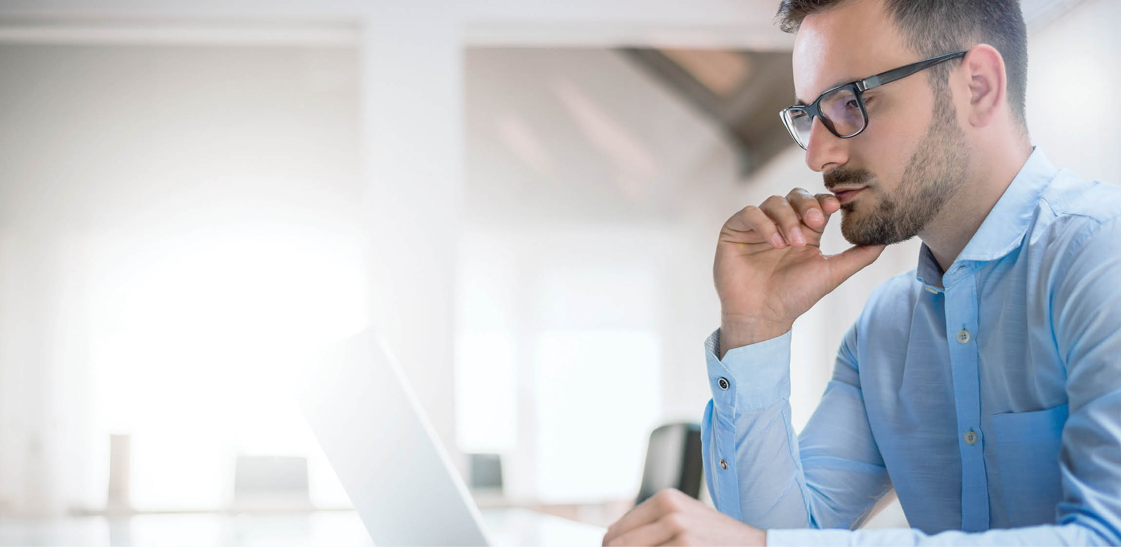 Portrait of young man sitting at his desk in the office