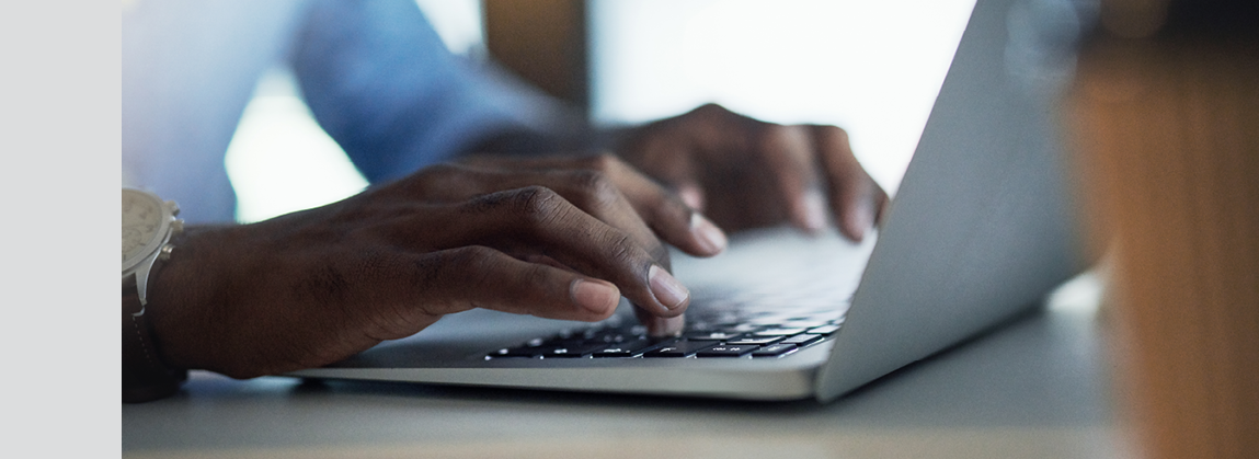 Closeup shot of an unrecognisable businessman working on a laptop in an office at night